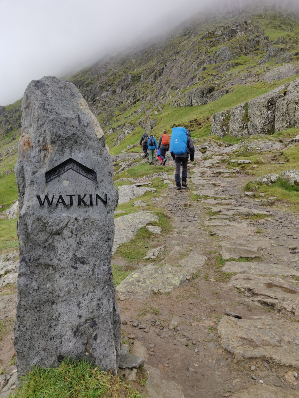 Rock sign post for the Watkin path which disappears into the clouds