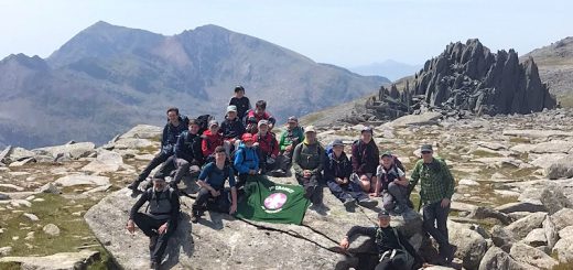Group photo with Group flag and Castle of the Winds and Snowdon in the background